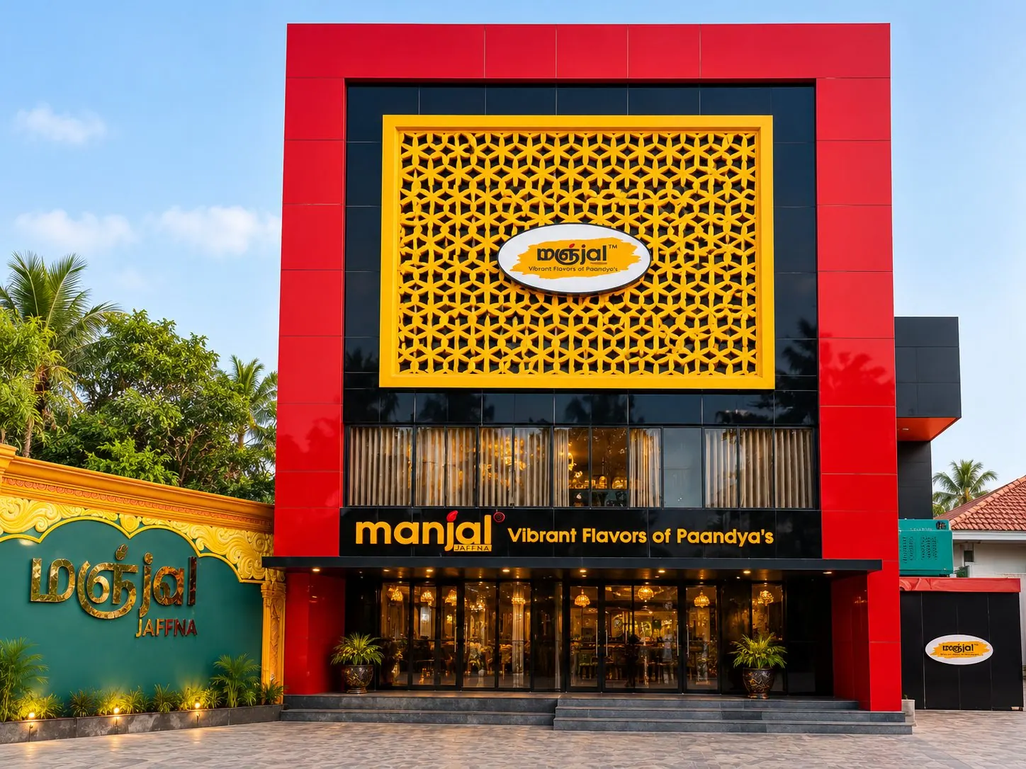 The red and yellow front of Manjal Jaffna restaurant with its jali screen and logo